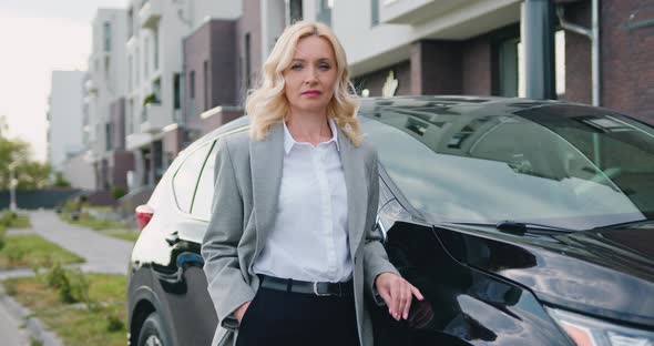 Businesswoman in Official Clothes Outside when Standing Beside Black Car on Parking