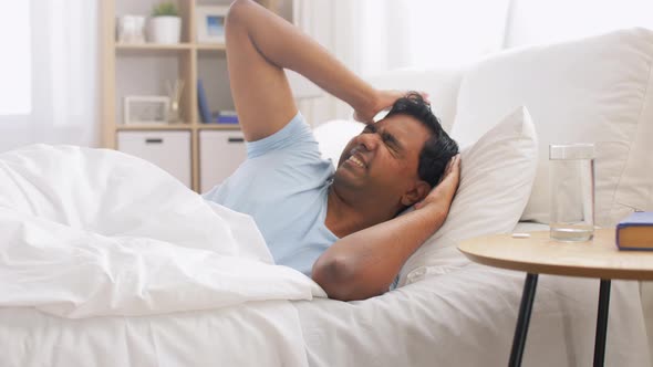 Man in Bed with Medicine and Glass of Water