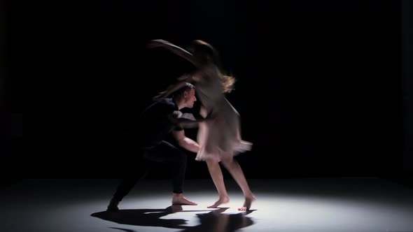 Man and Woman Performing a Contemporary Dance on Black, Shadow
