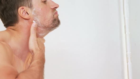 Young man standing in front of mirror washing his face with water in the bathroom 4K 4k