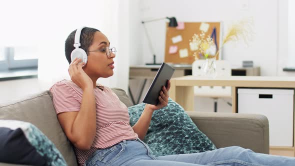 Woman with Tablet Pc Listening To Music at Home
