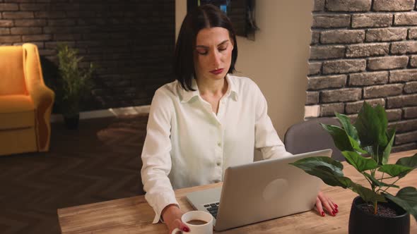 Tired Pretty Caucasian Woman Working on Laptop at the Home Office