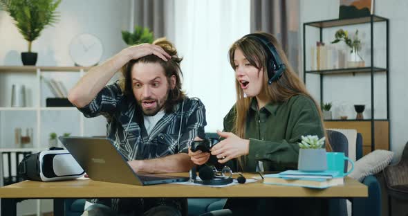 Young Couple Having Fun Together at Home when Playing Games on Laptop