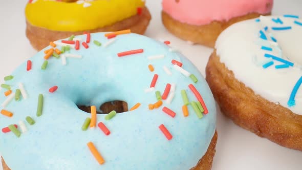 Delicious Multi-colored Donuts on a White Background. Smooth Dolly Motion