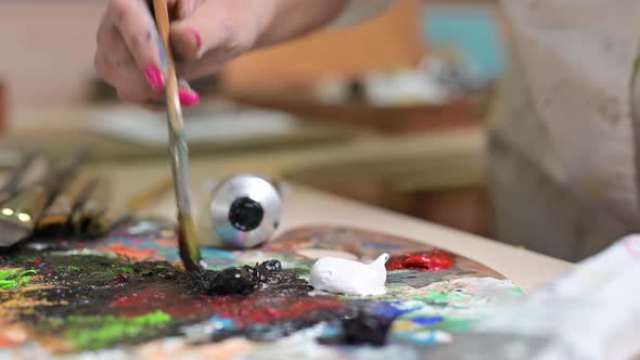 Creative Female Painter Mixes Palette of Oil Paints in Palette