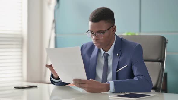 Young African Businessman Upset While Reading Documents in Office