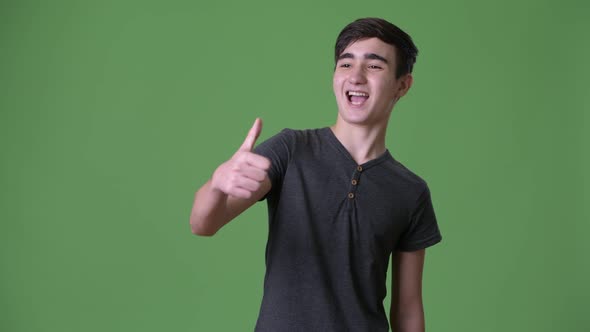 Young Handsome Iranian Teenage Boy Against Green Background