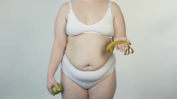 Plus Size Woman Showing Tape-Line and Apple Before Camera, Offer to Lose Weight