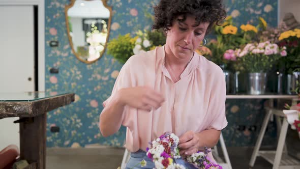 Woman creating flower wreath in florist shop