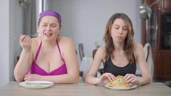 Medium Shot Portrait of Young Obese Woman Eating Healthful Organic Cucumber As Slim Beautiful