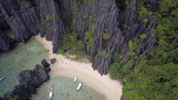 Aerial pedestal down on beach by limestone cliffs at Secret Lagoon in El Nido, Palawan, the Philippi