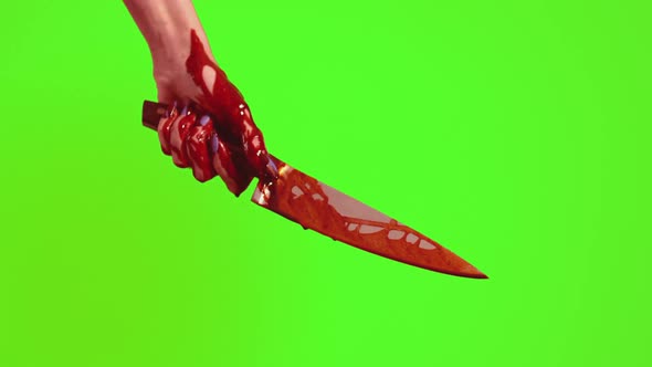 Blood Runs Down the Knife and Hand on a Green Background. The Killer's Hand Holds a Knife in Bright