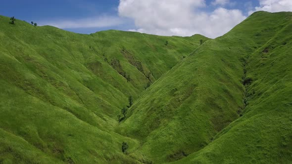 Aerial View. Flight Over a Green Grassy Rocky Hills