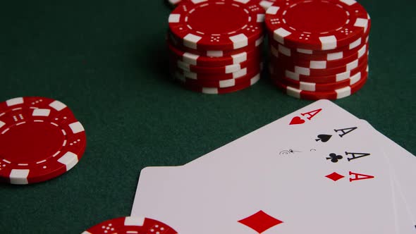 Rotating shot of poker cards and poker chips on a green felt surface - POKER 003
