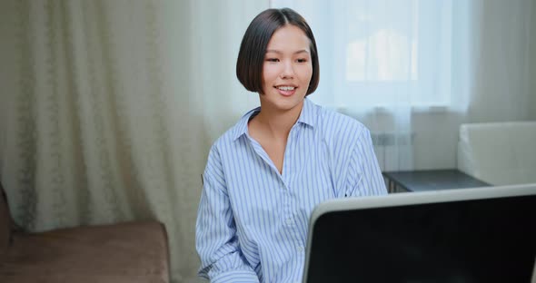 Online Student in Blue Shirt Talks Looking at Laptop Display