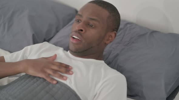 African Man Waking Up From Nightmare in Bed