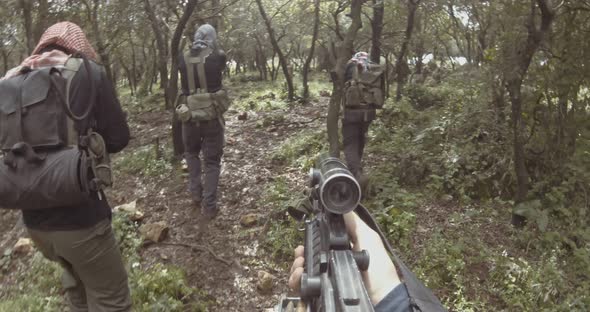 POV footage of armed terrorists patrolling a forest area