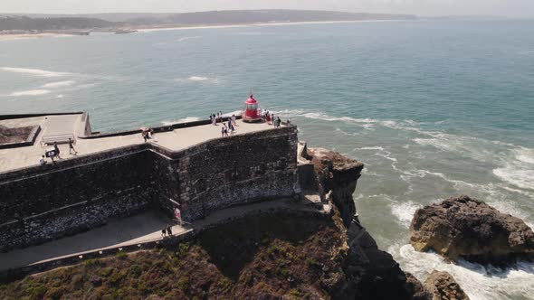 Aerial view Tourists exploring the Nazaré Lighthouse with Seascape as Background