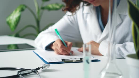 Woman Researcher, Doctor Fills Out Documents On Tablet. Portrait Of Doctor In Office At Desk