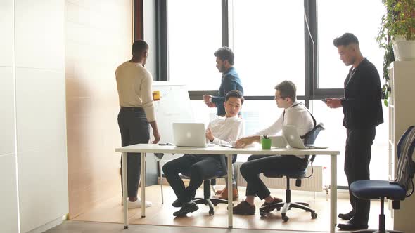 Multiethnic Businessmen Debating Vivaciously During Working Meeting in Conference Room