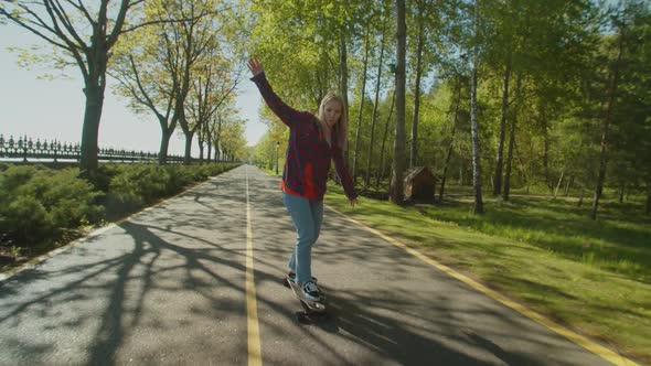 Pretty Female Skateboarder Enjoying Freedom and Leisure During Skateboarding