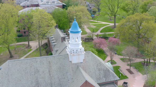 Aerial of blue painted bellfry atop large building on American university campus in Lancaster Pennsy