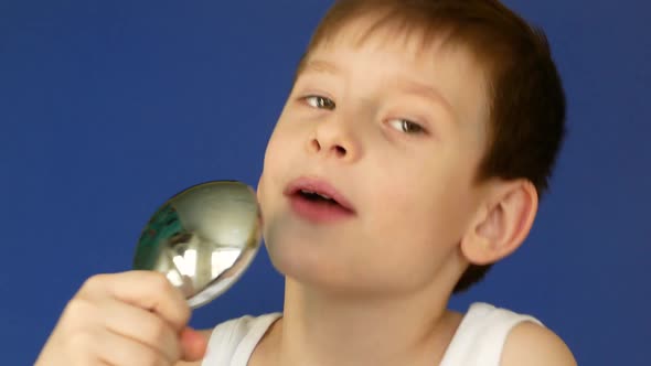 Playful caucasian boy 6-7 years old singing in the bathroom holding a shower microphone,