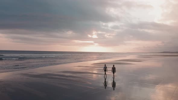 Couple Walking on Beach at Sunset