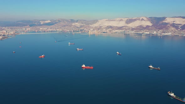 Aerial View of Several Large and Small Ships in Sea Bay, City View on Background