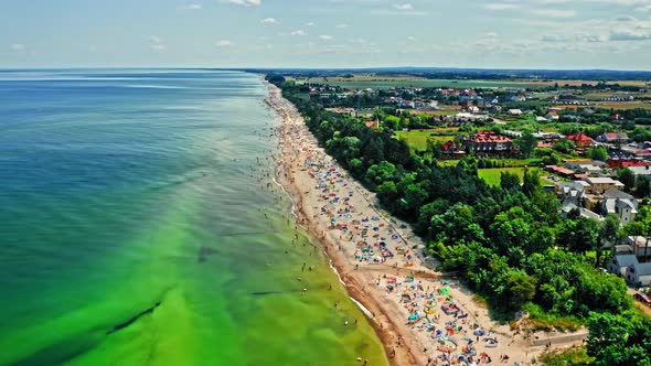 Flying above beach with people in Baltic Sea, Poland