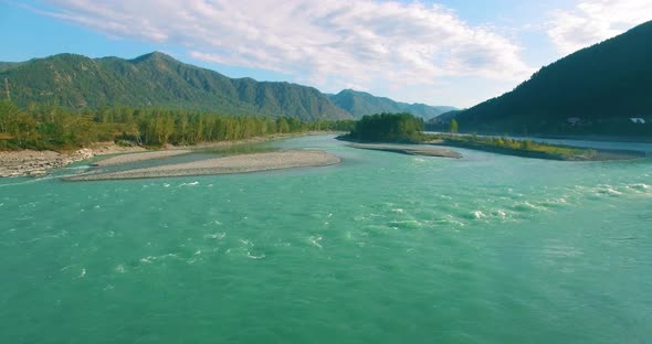 Low Altitude Flight Over Fresh Fast Mountain River with Rocks at Sunny Summer Morning