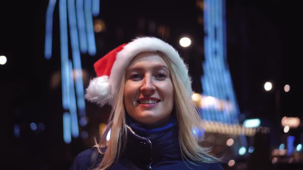 Portrait of a woman smiling at the camera and playing in a Santa hat