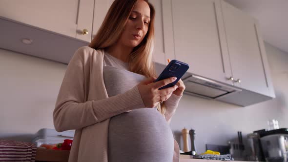 Pregnant woman eating healthy food and using mobile phone. Shot with RED helium camera in 8K