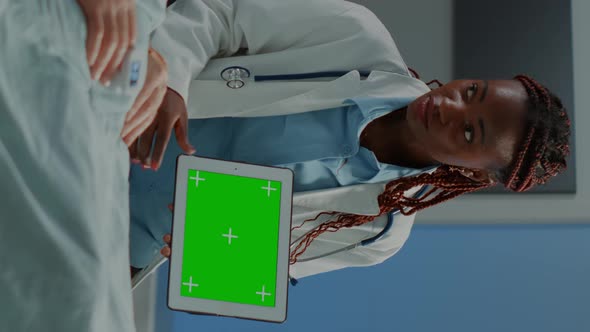 Vertical Video Specialist Woman Showing Green Screen on Tablet to Patient