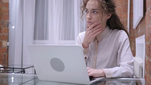 Woman Brainstorming for Online Work on Laptop In Office