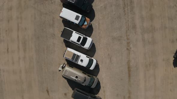 A top-down fly over a line of motorhomes in the desert