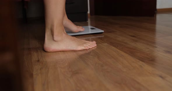 Woman Putting in Bed and Weighing on Floor Scales Closeup  Movie