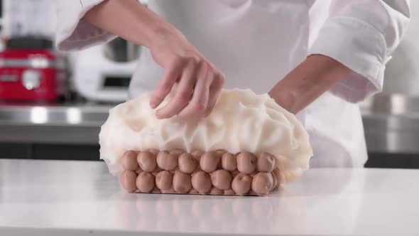 Pastry Chef Scrapes the Frozen Cake Out of Silicone Mold for Glazing