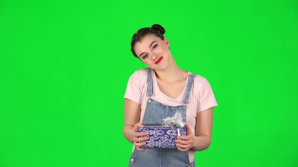 Pretty Girl Holds Gift Is Surprised and Very Happy on Green Screen