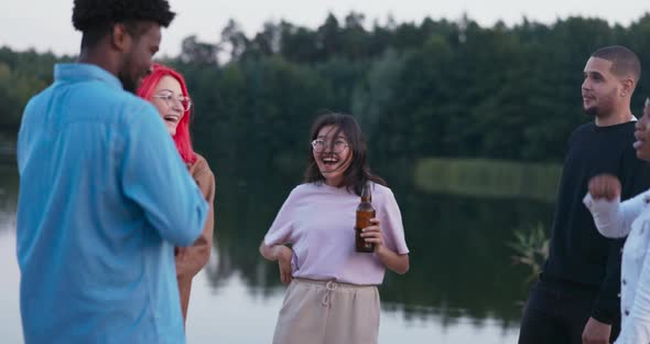 Party of Students on the Beach Dancing in the Evening By the Fire Young People of Different