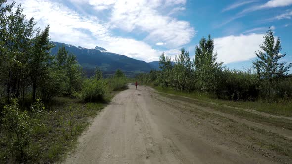 Fit woman jogging through road 4k