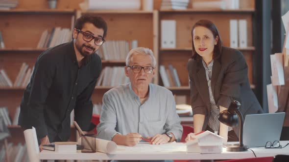 Group of Positive Mixed-Aged Architects Posing for Camera with Smile