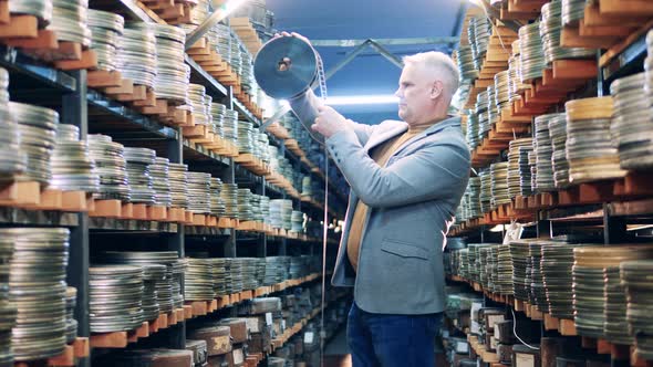 An Archivist is Inspecting Vintage Movie Tapes