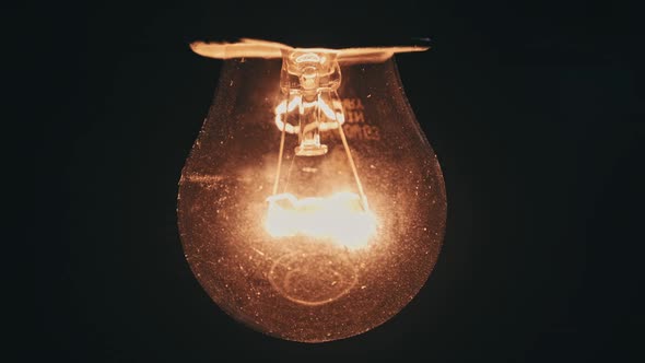 Light Bulb Slowly Turned On and Off on Black Background