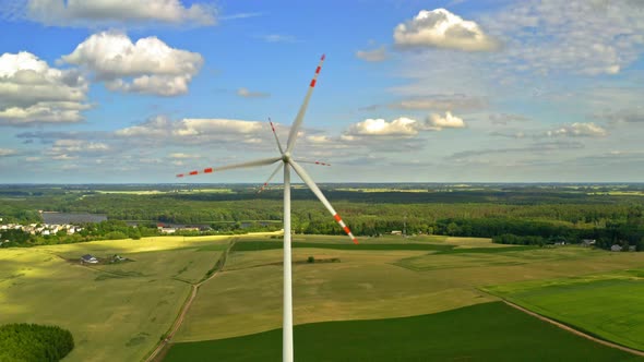 Wind turbines on green field ith blue sky in Poland, aerial view alt