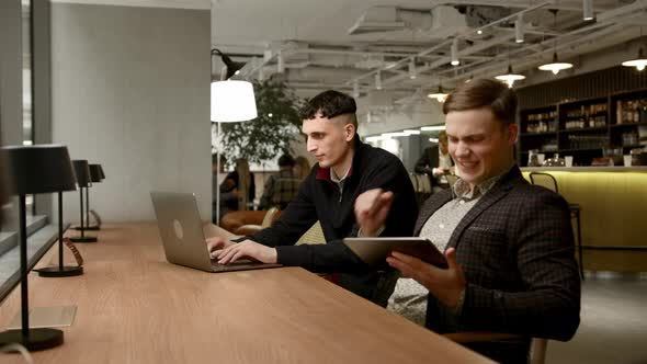 Male managers of the company work behind laptops in the office