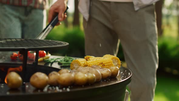 Male Chef Using Forceps for Cooking Food Outdoors