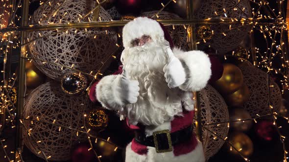 Cheerful and Funny Santa Claus Showing Thumbs Up Looking at the Camera