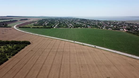Aerial View of Highway Road Between Meadow and Agricultural Field.
