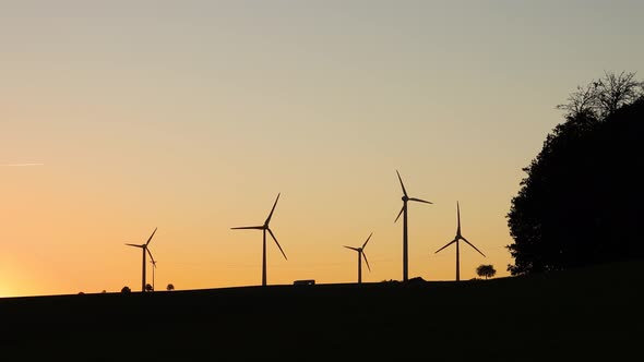 Silhouette of wind turbines at sunset. 